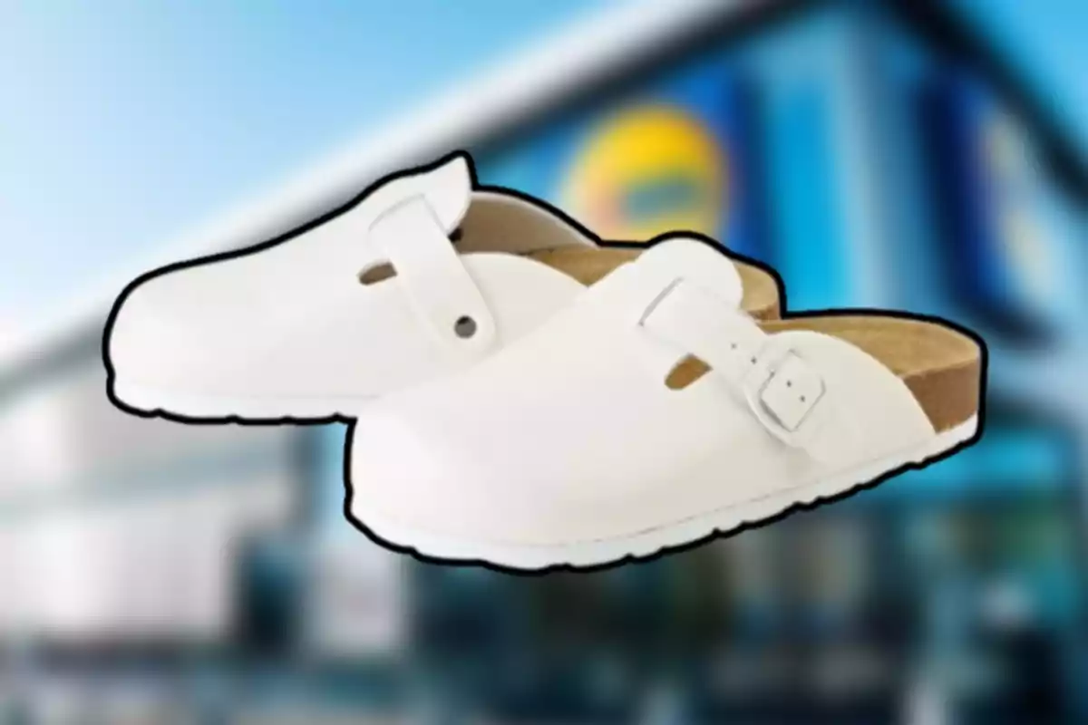 Un par de sandalias blancas tipo zueco con hebilla sobre un fondo borroso de una tienda Un par de sandalias blancas tipo zueco con hebilla sobre un fondo borroso de una tienda