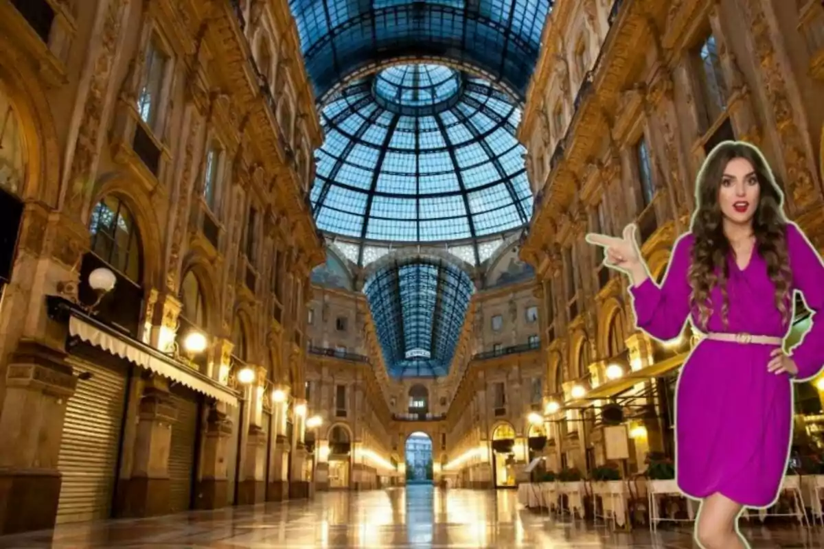 Una mujer con vestido morado posando frente a una galería comercial con techo de cristal y arquitectura clásica.