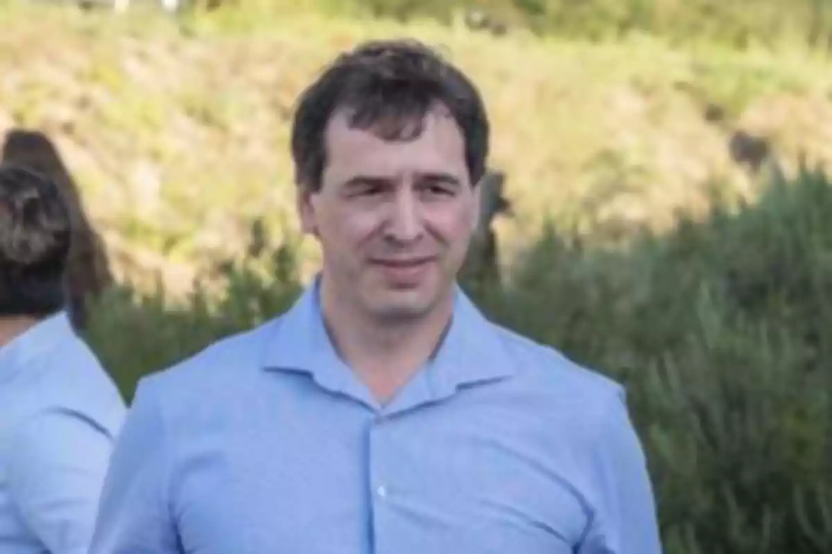 A man in a light blue jersey in a natural setting.