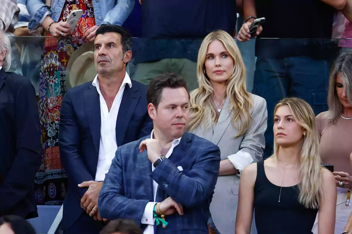 A group of elegantly dressed people is alertly watching a sporting event from the stands. A group of elegantly dressed people is alertly watching a sporting event from the stands.