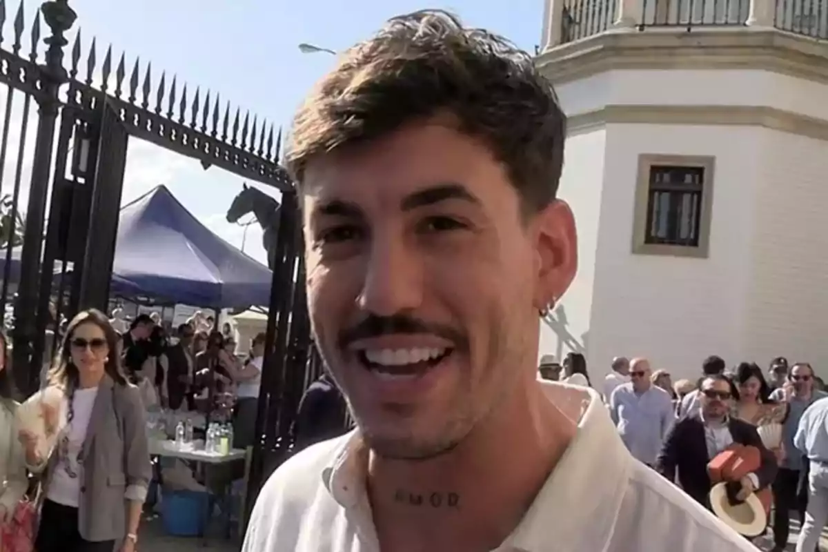 Luitingo con un tatuaje en el cuello está en un evento al aire libre rodeado de personas y una estructura de hierro. Luitingo con un tatuaje en el cuello está en un evento al aire libre rodeado de personas y una estructura de hierro.