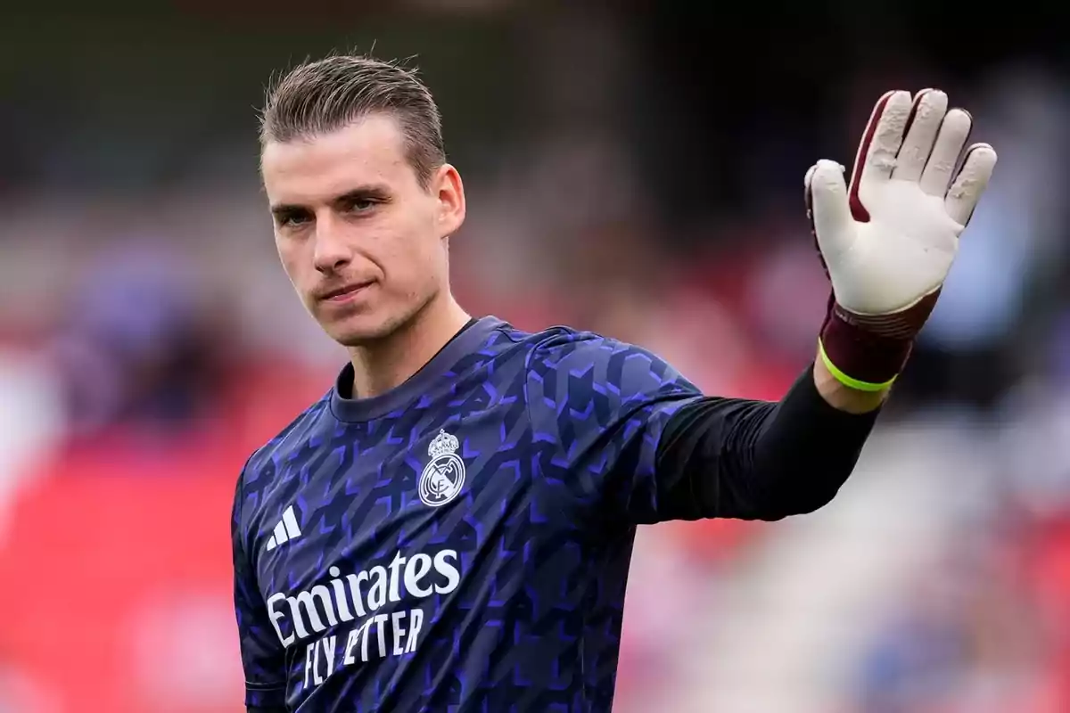 Andriy Lunin saluda a los aficionados con los guantes puestos y la camiseta de calentamiento del Real Madrid