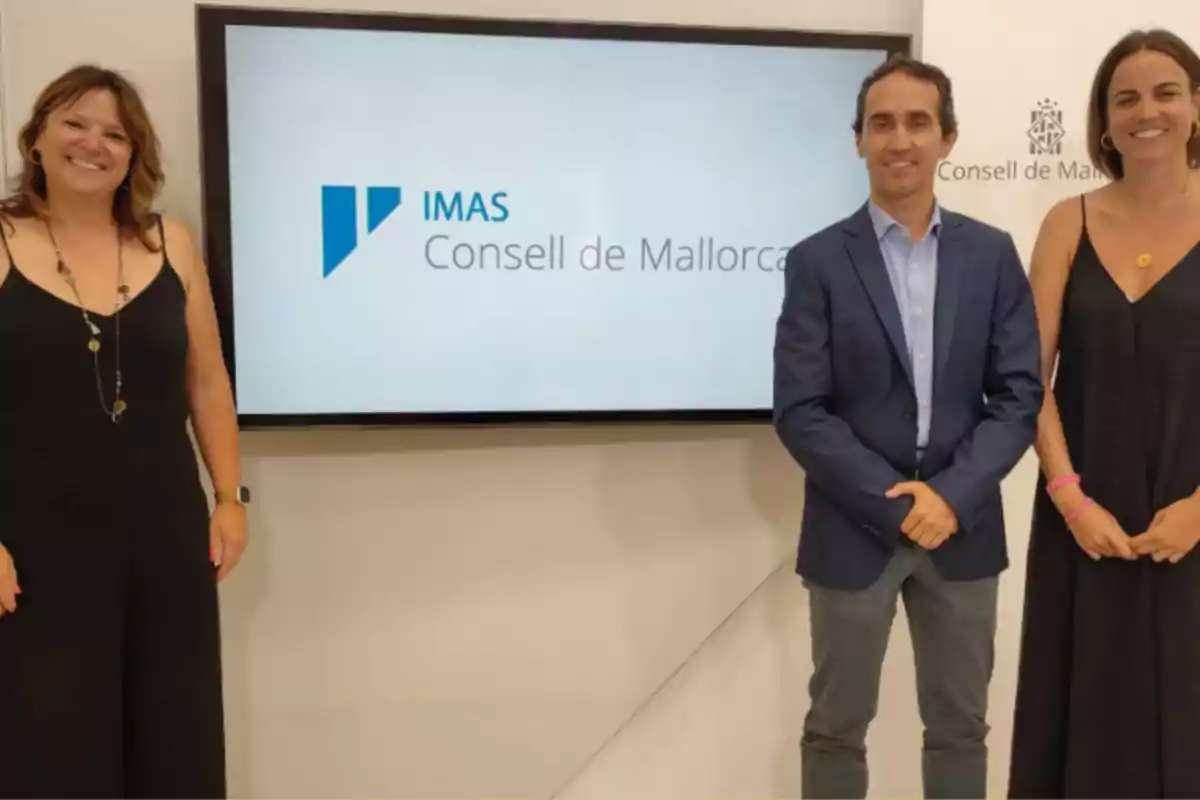 Tres personas posando frente a una pantalla que muestra el logo de IMAS Consell de Mallorca.