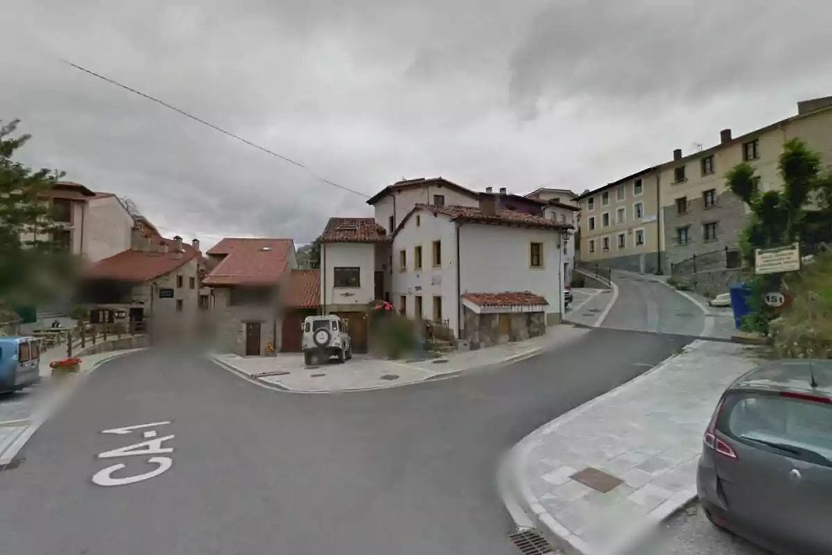 Una intersección en un pueblo con casas de estilo tradicional y un cielo nublado. Una intersección en un pueblo con casas de estilo tradicional y un cielo nublado.