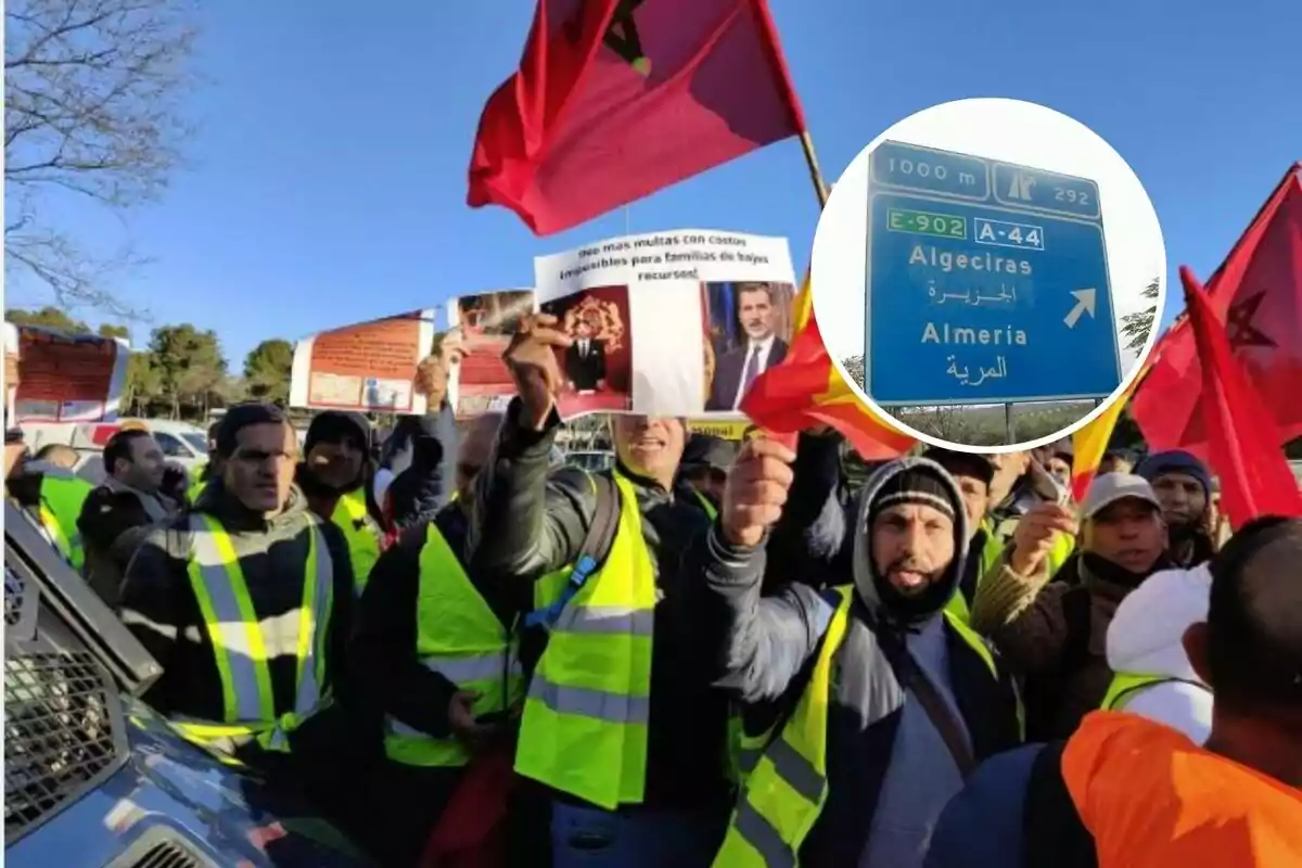 A group of people in yellow vests holds flags and banners at a demonstration, with a road sign indicating directions to Algeciras and Almería in a box.