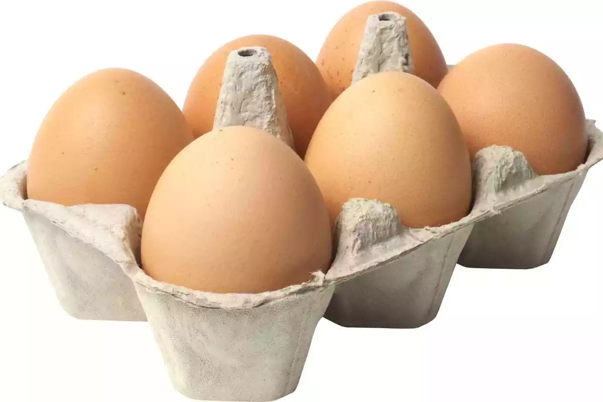 Media docena de huevos sobre un fundo blanco