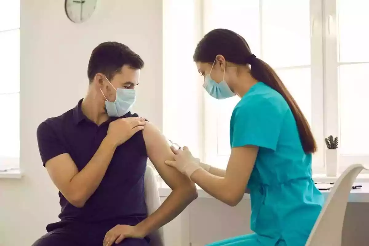 Un médico vacunando a un paciente