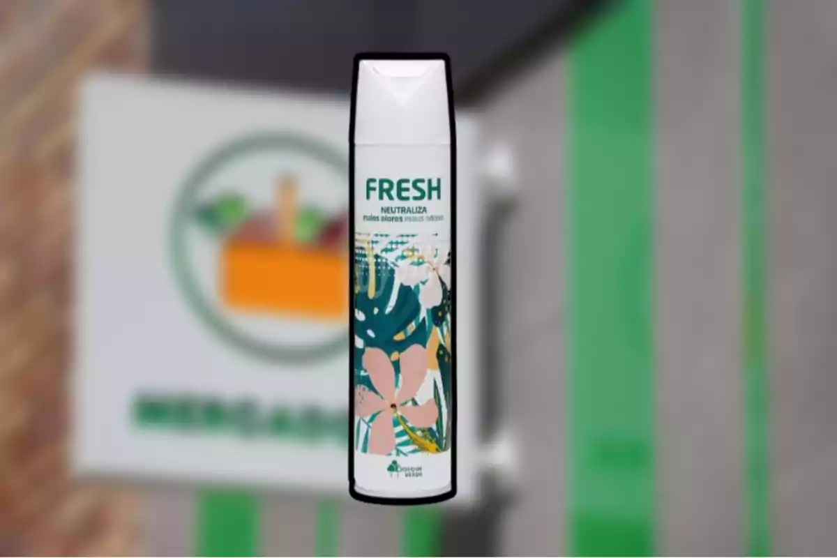 Envase de aerosol Fresh neutralizador de malos olores con diseño floral sobre un fondo borroso de una pared y un letrero Envase de aerosol Fresh neutralizador de malos olores con diseño floral sobre un fondo borroso de una pared y un letrero