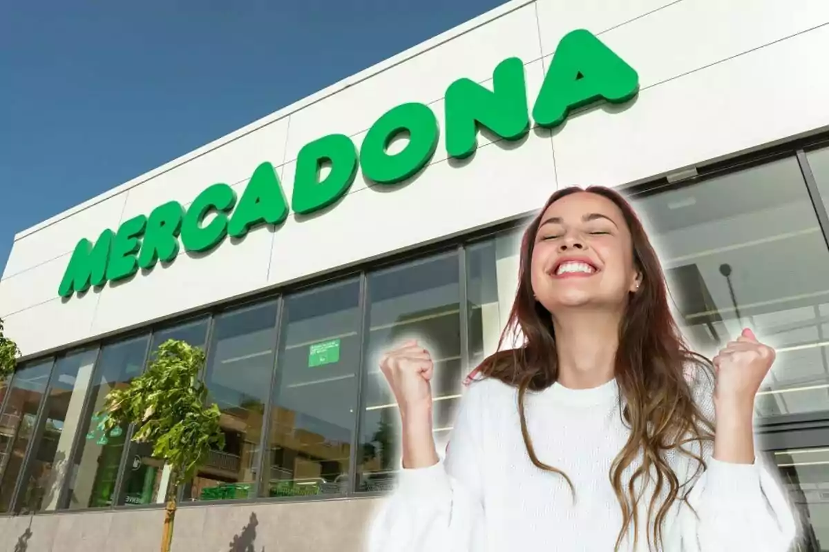 Una mujer sonriente con los puños levantados frente a una tienda de Mercadona.