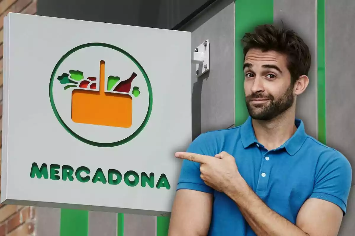 Un hombre con camisa azul señala un letrero de Mercadona que tiene un logotipo de una cesta con alimentos.