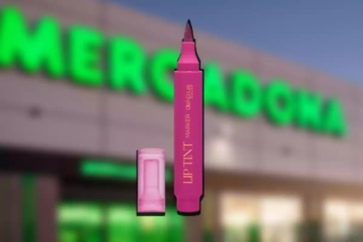 Un rotulador de tinte labial rosa con la tapa quitada frente a un supermercado Mercadona. Un rotulador de tinte labial rosa con la tapa quitada frente a un supermercado Mercadona.