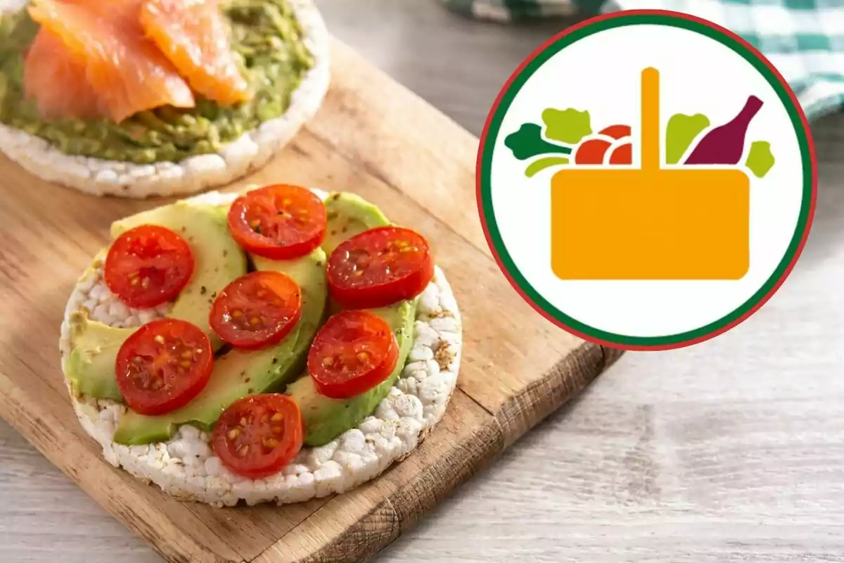 Dos tortitas de arroz con aguacate, jitomate y salmón sobre una tabla de madera junto a un icono de una canasta de alimentos. Dos tortitas de arroz con aguacate, jitomate y salmón sobre una tabla de madera junto a un icono de una canasta de alimentos.