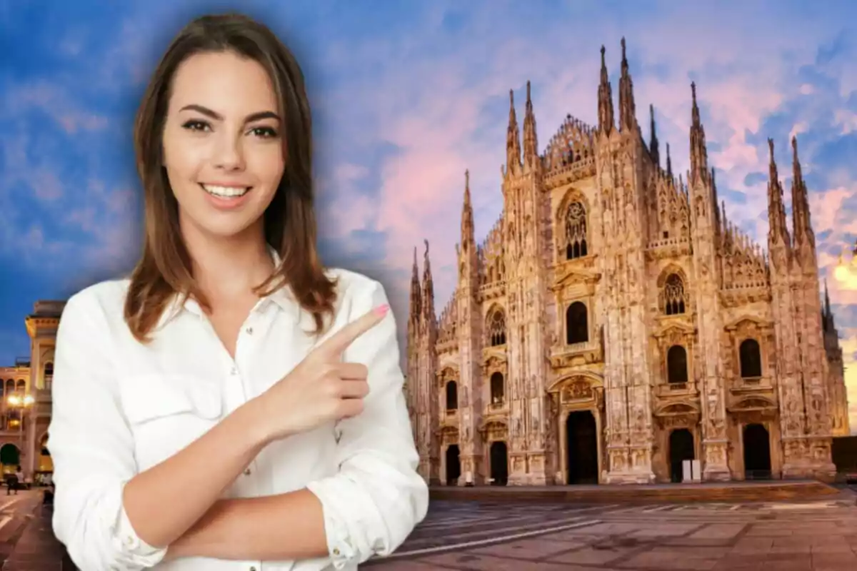 Una mujer sonriente con una camisa blanca señala hacia la Catedral de Milán al atardecer.