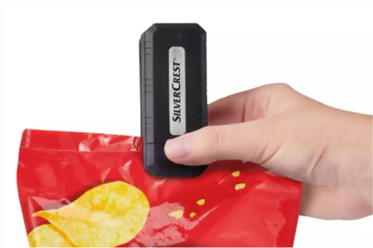 Persona usando un sellador portátil de bolsas para cerrar un paquete de papas fritas rojo Persona usando un sellador portátil de bolsas para cerrar un paquete de papas fritas rojo
