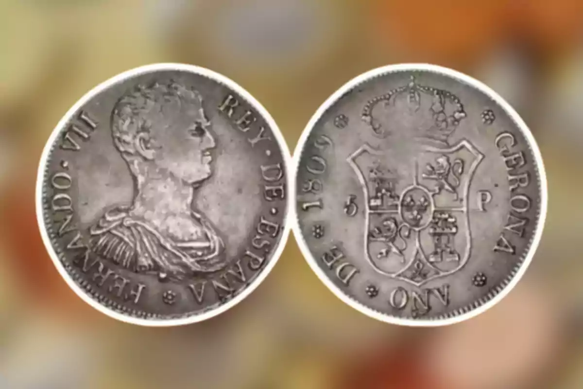 Moneda antigua de plata con el perfil de un monarca y un escudo heráldico en el reverso. Moneda antigua de plata con el perfil de un monarca y un escudo heráldico en el reverso.