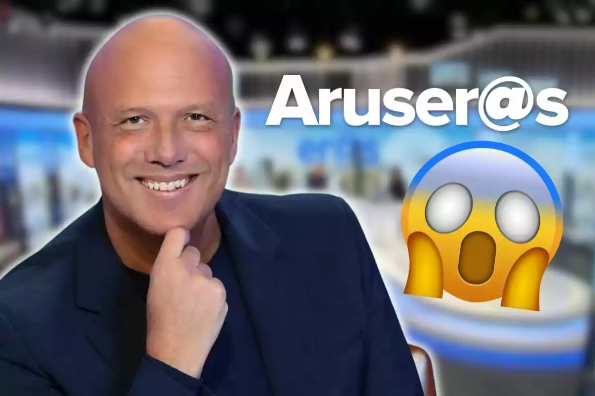 Un hombre calvo sonriente con fondo de estudio de televisión y un emoji sorprendido al lado.