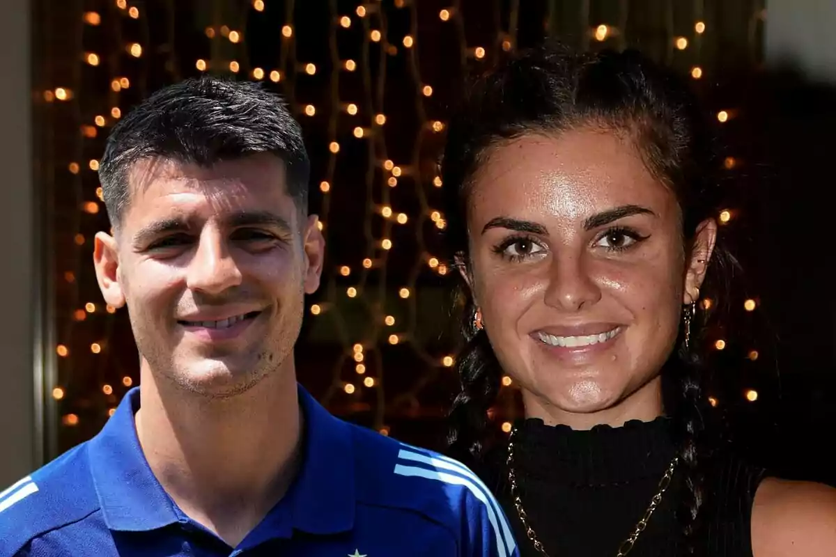 Álvaro Morata y Alexia Rivas sonrientes posando frente a un fondo de luces decorativas.