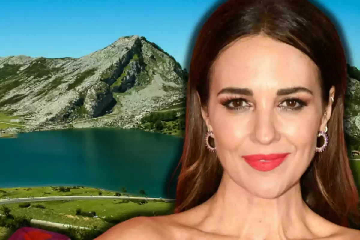 Paula Echevarría con labios rojos en primer plano con un lago y montañas al fondo bajo un cielo azul