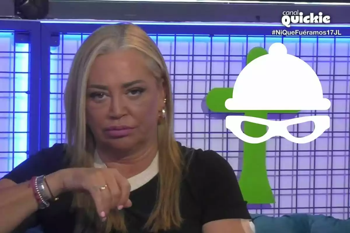 Belén Esteban con cabello rubio y expresión seria, sentada frente a un fondo con luces azules y una figura verde, con un logotipo de un canal de televisión y un hashtag en la esquina superior derecha.