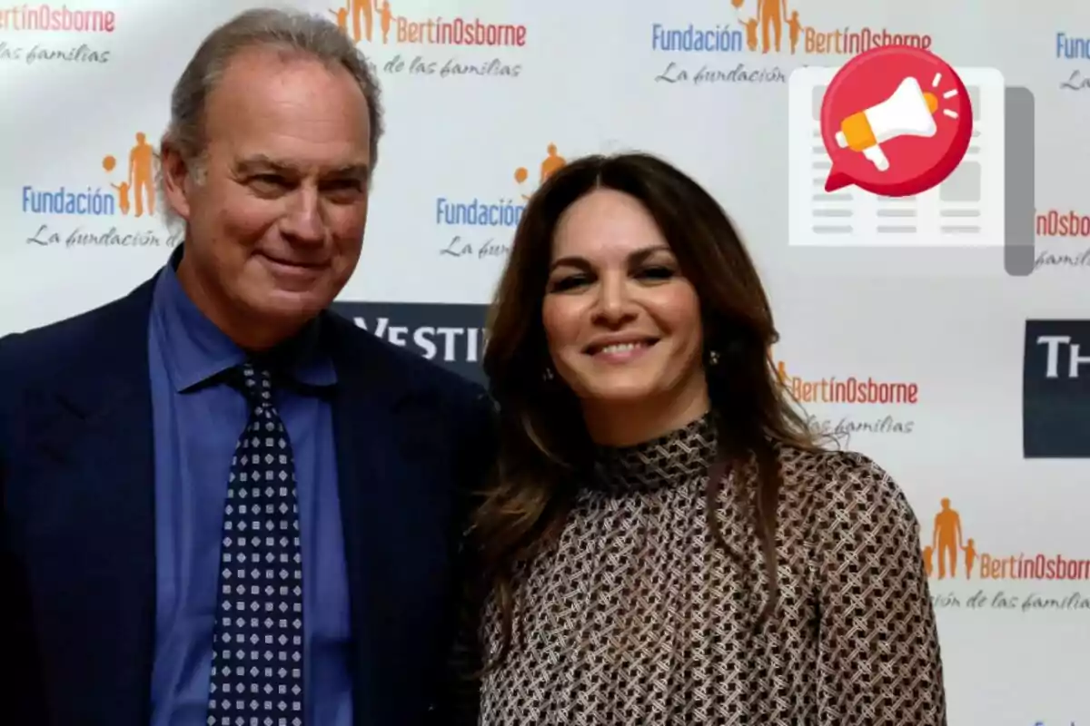 Bertín Osborne y Fabiola Martínez posan juntas frente a un fondo con logotipos de una fundación.