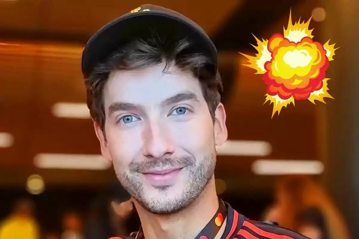 Carlos Torres, wearing a black cap and a jersey with red details, smiles as an explosion graphic appears in the background.