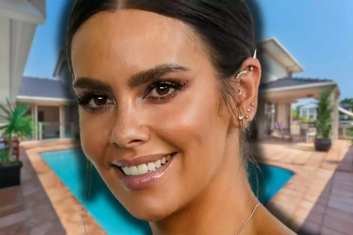 Cristina Pedroche sonriente con varios piercings en la oreja frente a una casa moderna con piscina