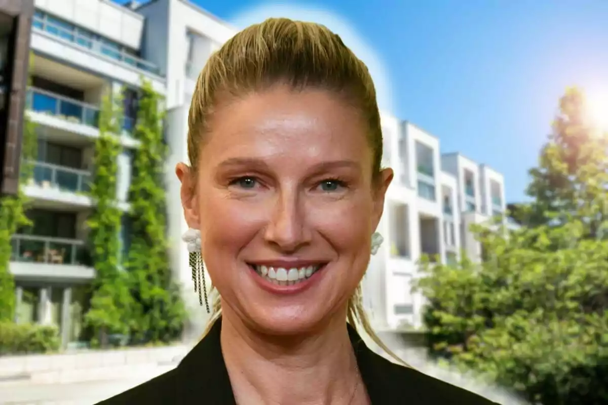 Anne Igartiburu sonriendo frente a un edificio moderno con vegetación y cielo despejado.