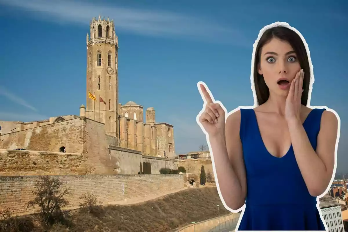 Mujer sorprendida señalando una catedral antigua con una torre alta bajo un cielo despejado.