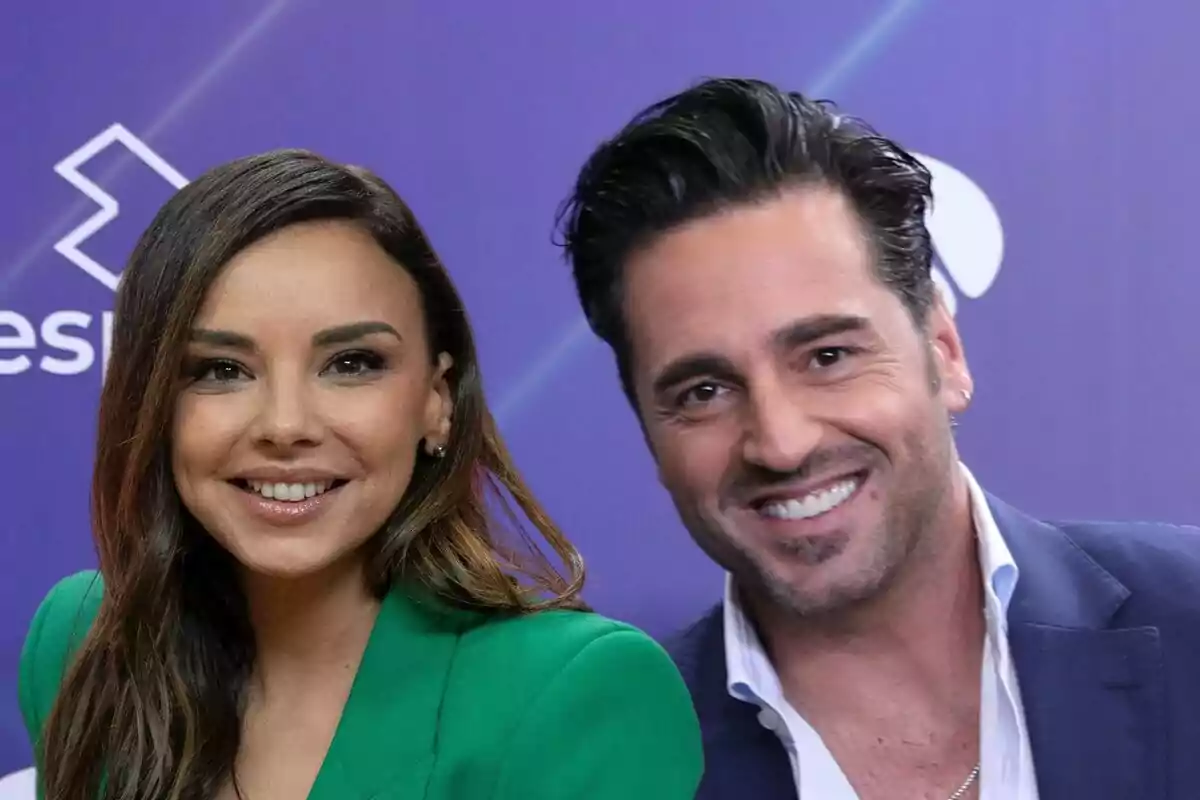 Chenoa y David Bustamante sonrientes posando frente a un fondo púrpura con un logotipo blanco.