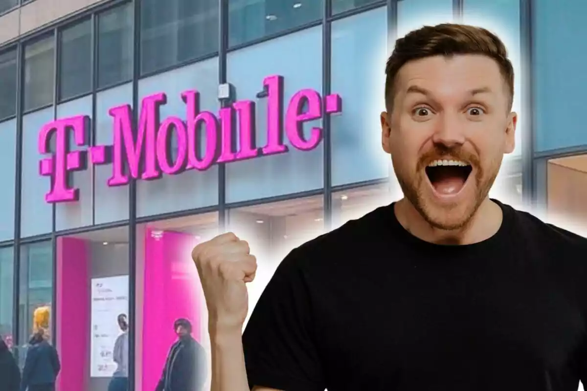 Un hombre emocionado con el puño levantado frente a una tienda de T-Mobile.