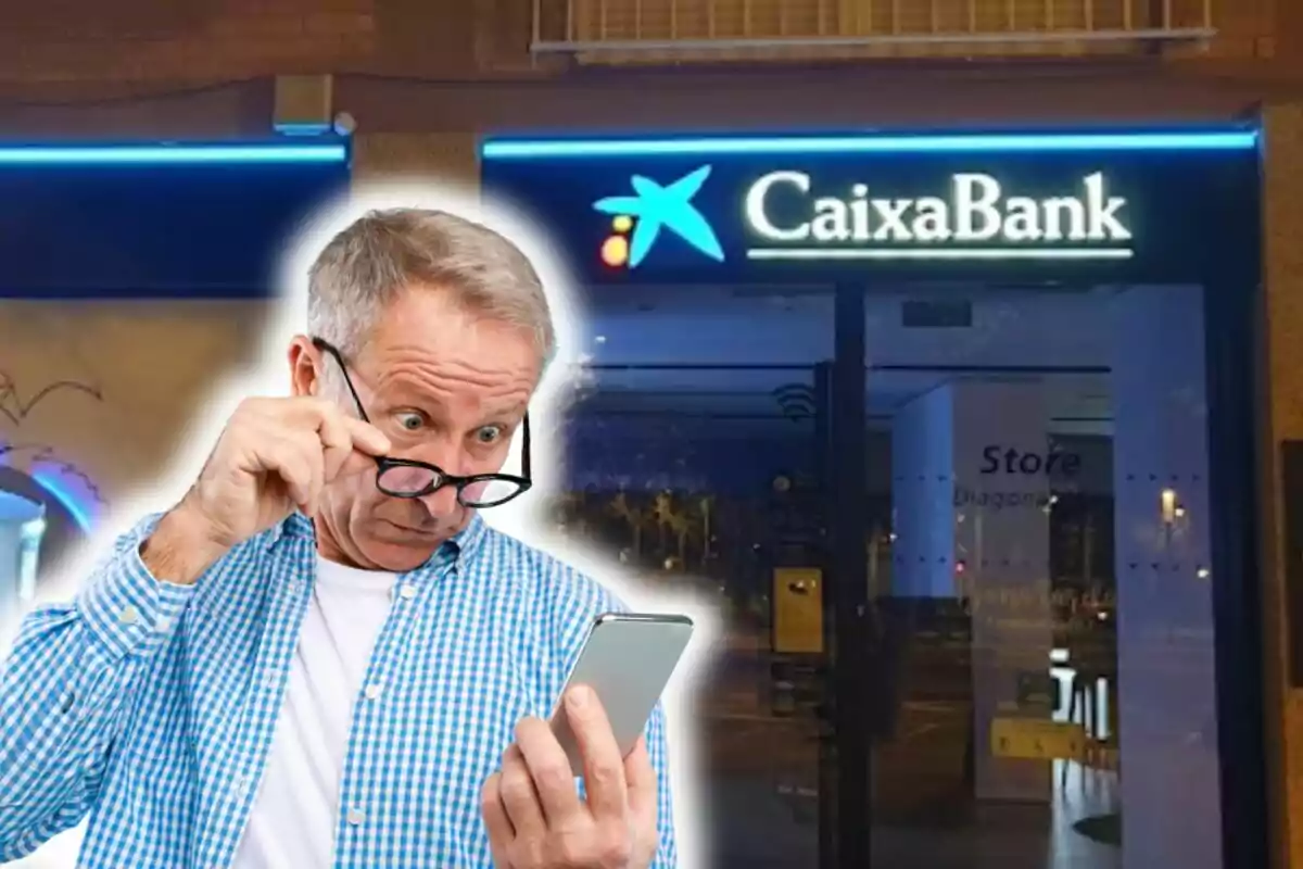 Senior man looking at his mobile phone with a surprised expression in front of a CaixaBank branch.