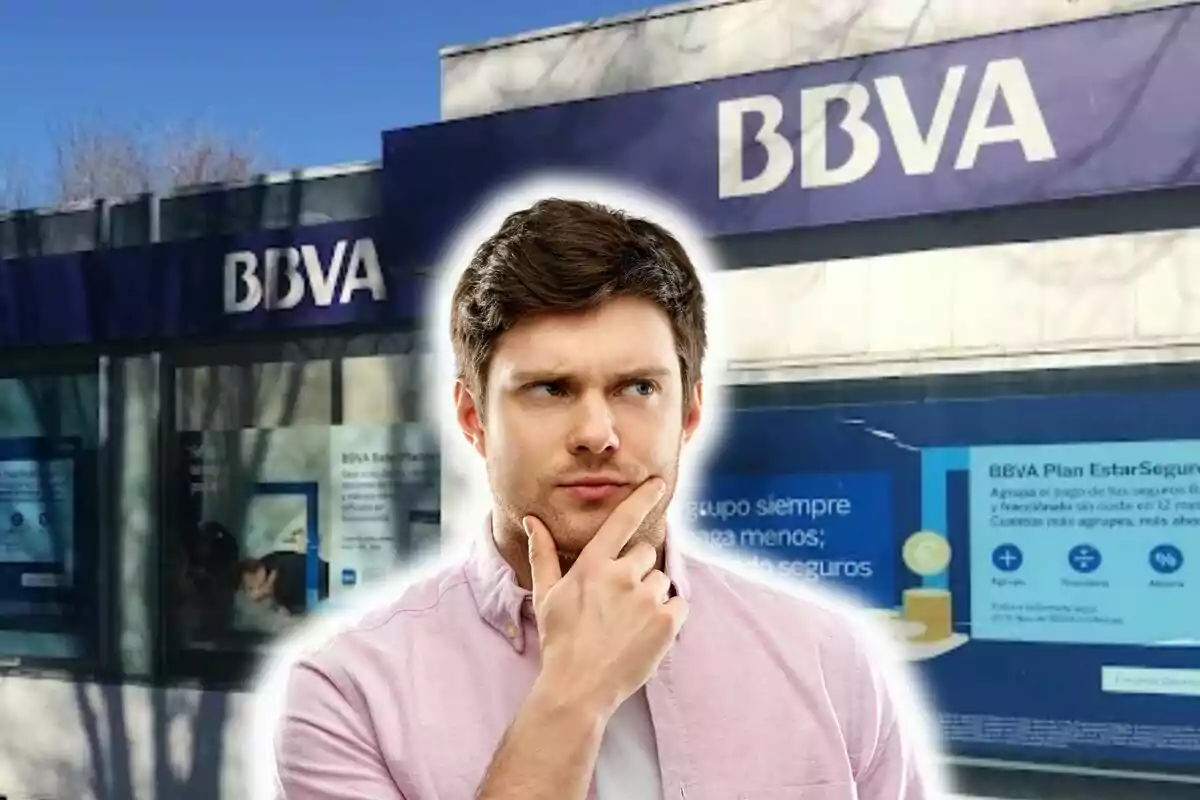 A pensive man in front of a BBVA bank branch.