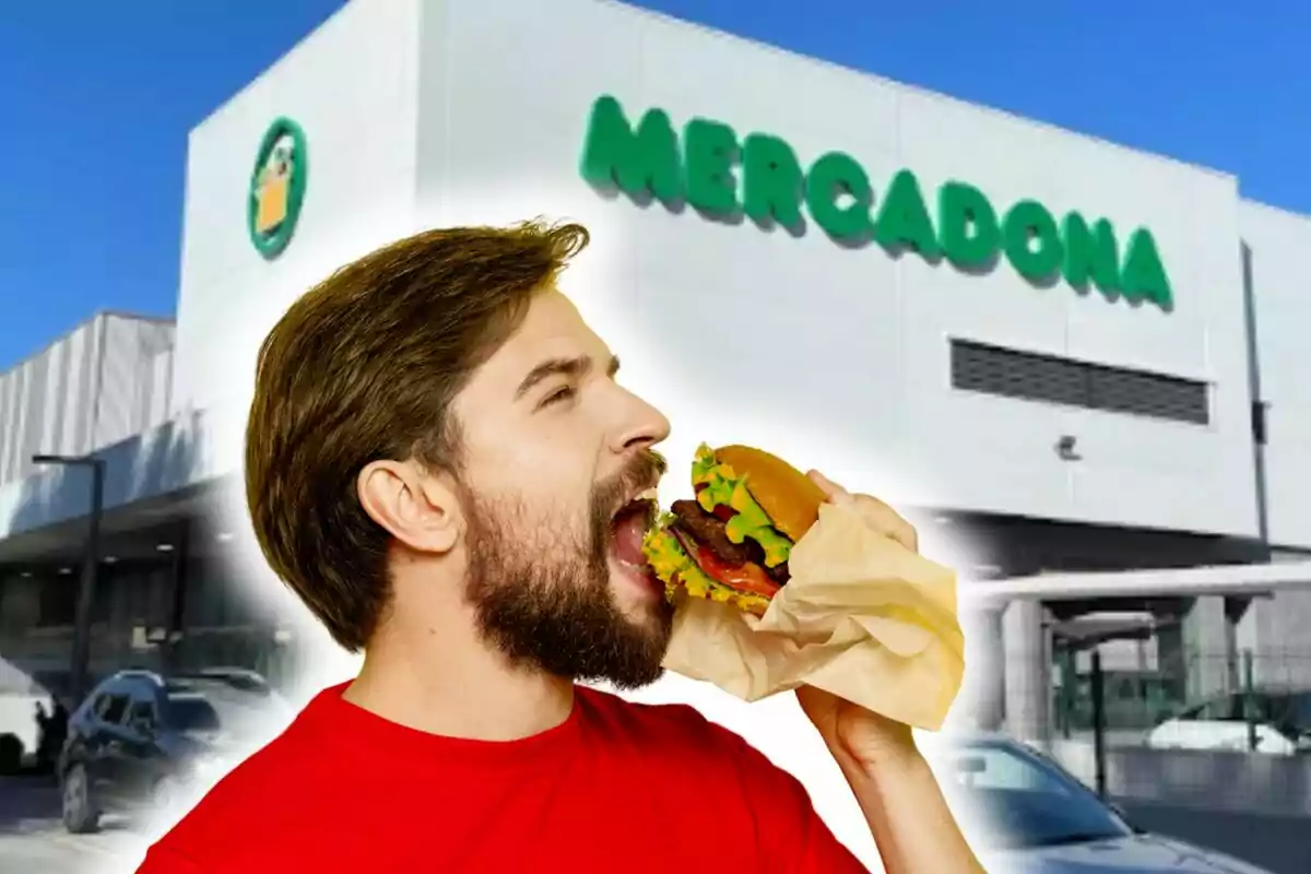 Un hombre con barba y camiseta roja está a punto de morder una hamburguesa frente a un edificio con el letrero de Un hombre con barba y camiseta roja está a punto de morder una hamburguesa frente a un edificio con el letrero de