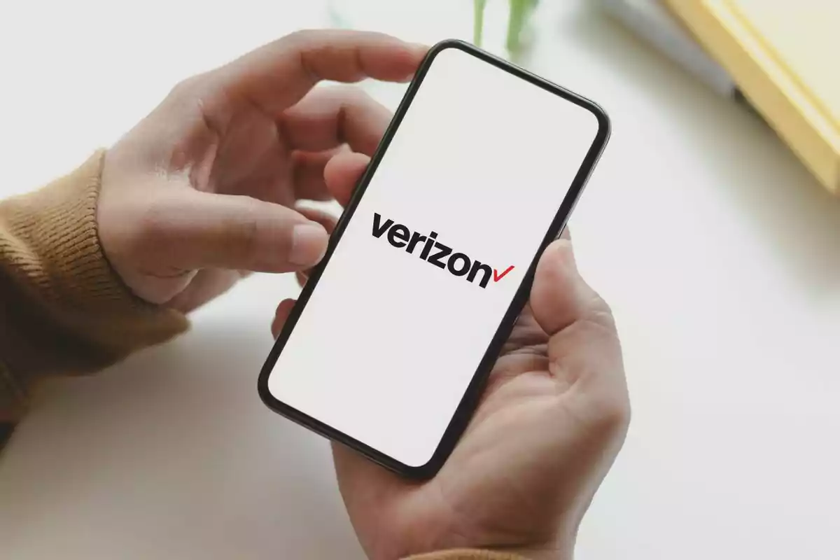 Persona sosteniendo un teléfono móvil que muestra el logotipo de Verizon en la pantalla. Persona sosteniendo un teléfono móvil que muestra el logotipo de Verizon en la pantalla.