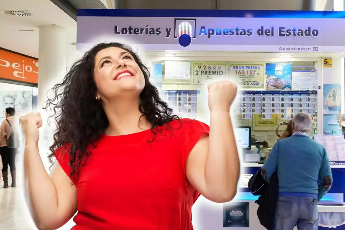 Una mujer con una camiseta roja celebra con los puños en alto frente a una administración de Loterías y Apuestas del Estado.