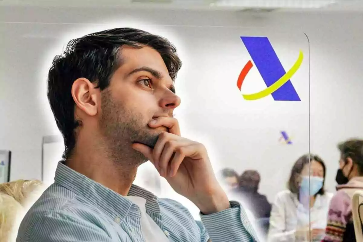 A thoughtful man with his hand on his chin, in an office environment with people in the background and a colorful logo on the glass.