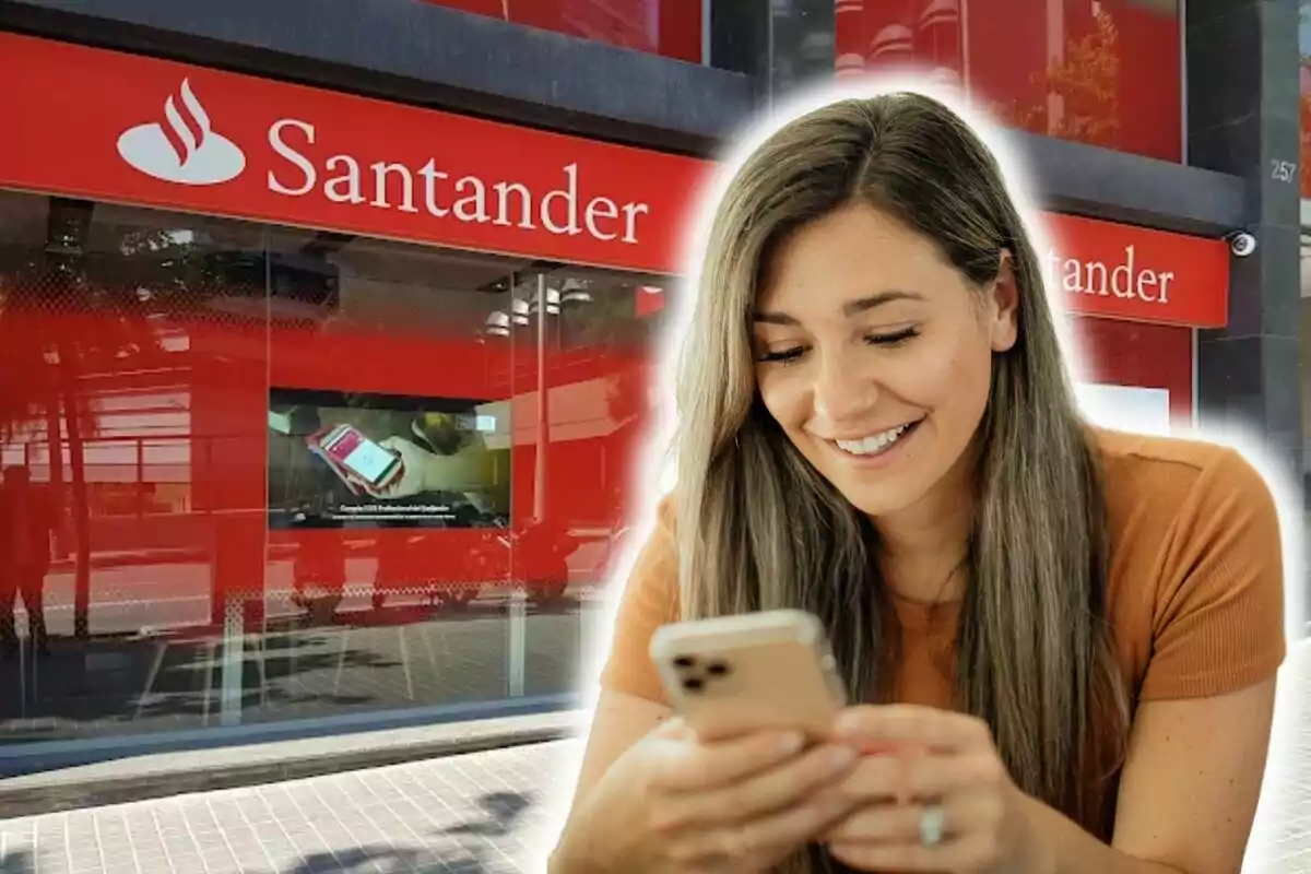 Una mujer sonriente usando su teléfono móvil frente a una sucursal del banco Santander.