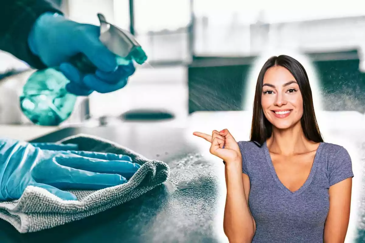 Una persona sonriente señala hacia una mano con guantes azules que limpia una superficie con un paño y un rociador.