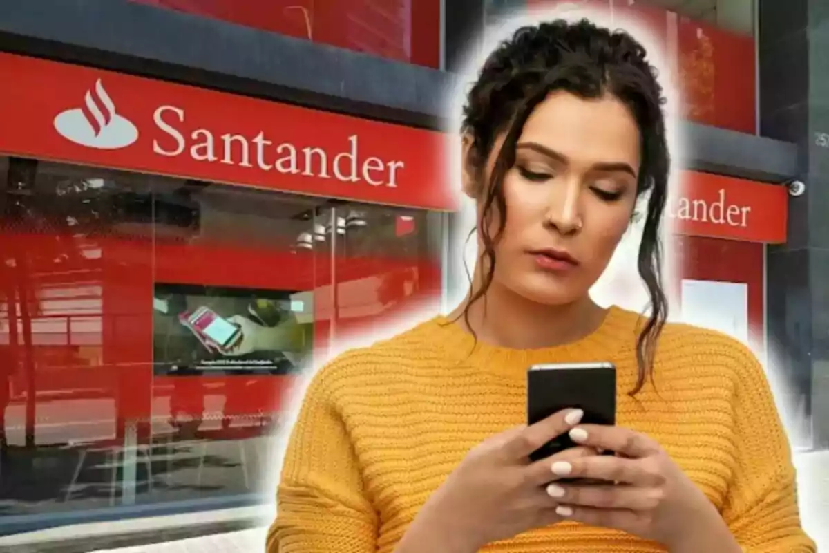 Mujer con suéter amarillo usando un teléfono frente a una sucursal bancaria del Banco Santander.