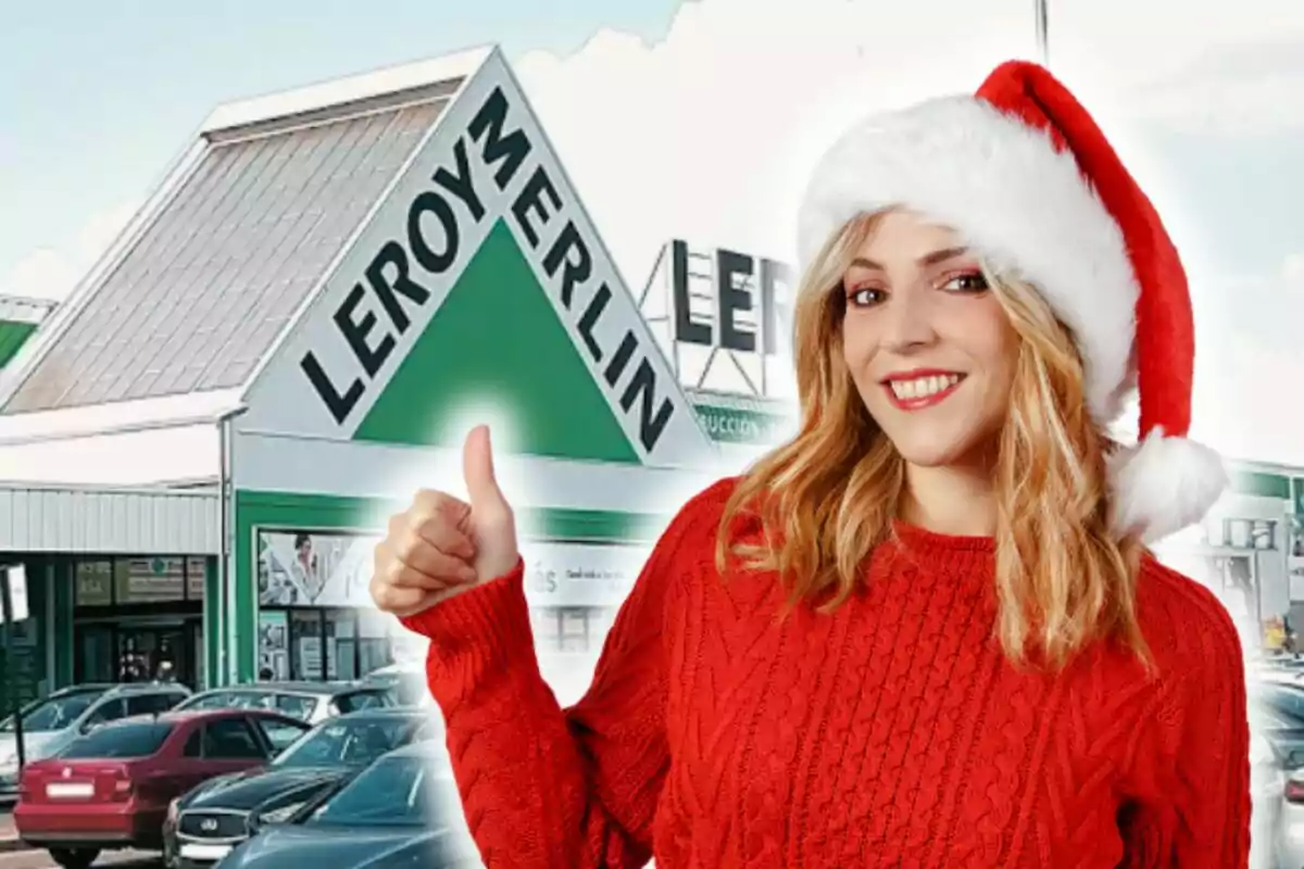 Una mujer sonriente con un gorro de Navidad y un suéter rojo hace un gesto de aprobación frente a una tienda de Leroy Merlin.