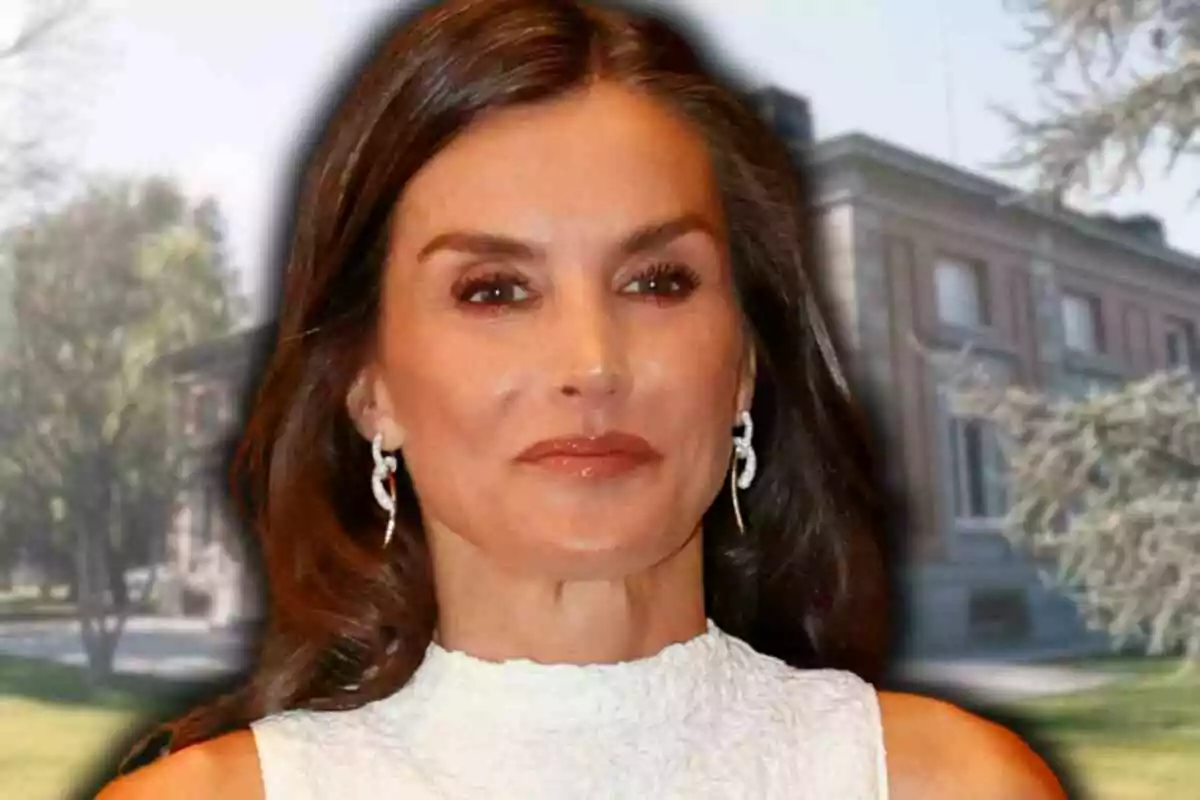 Queen Letizia in a sleeveless white dress and silver earrings posing in front of Zarzuela's building surrounded by trees