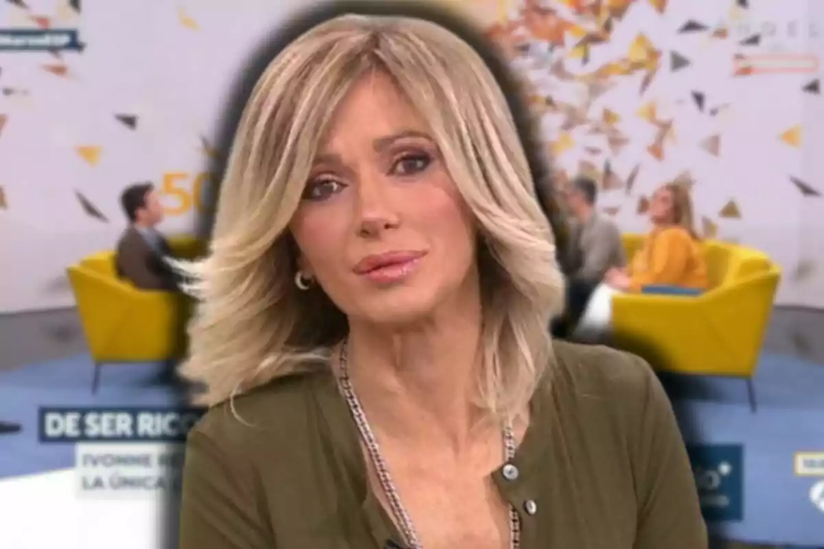 Susanna Griso con maquillaje sutil está en primer plano mientras en el fondo se observa un set de televisión con personas sentadas en sillones amarillos.