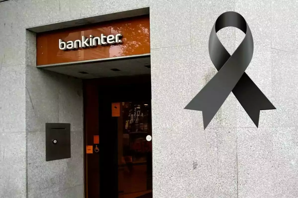 Entrada de una sucursal de Bankinter con un lazo negro de luto en la pared.