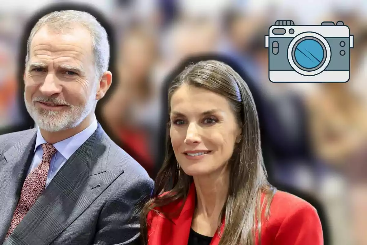 Felipe VI and Queen Letizia, elegantly dressed, posing in front of a blurred background with a camera icon in the top right corner