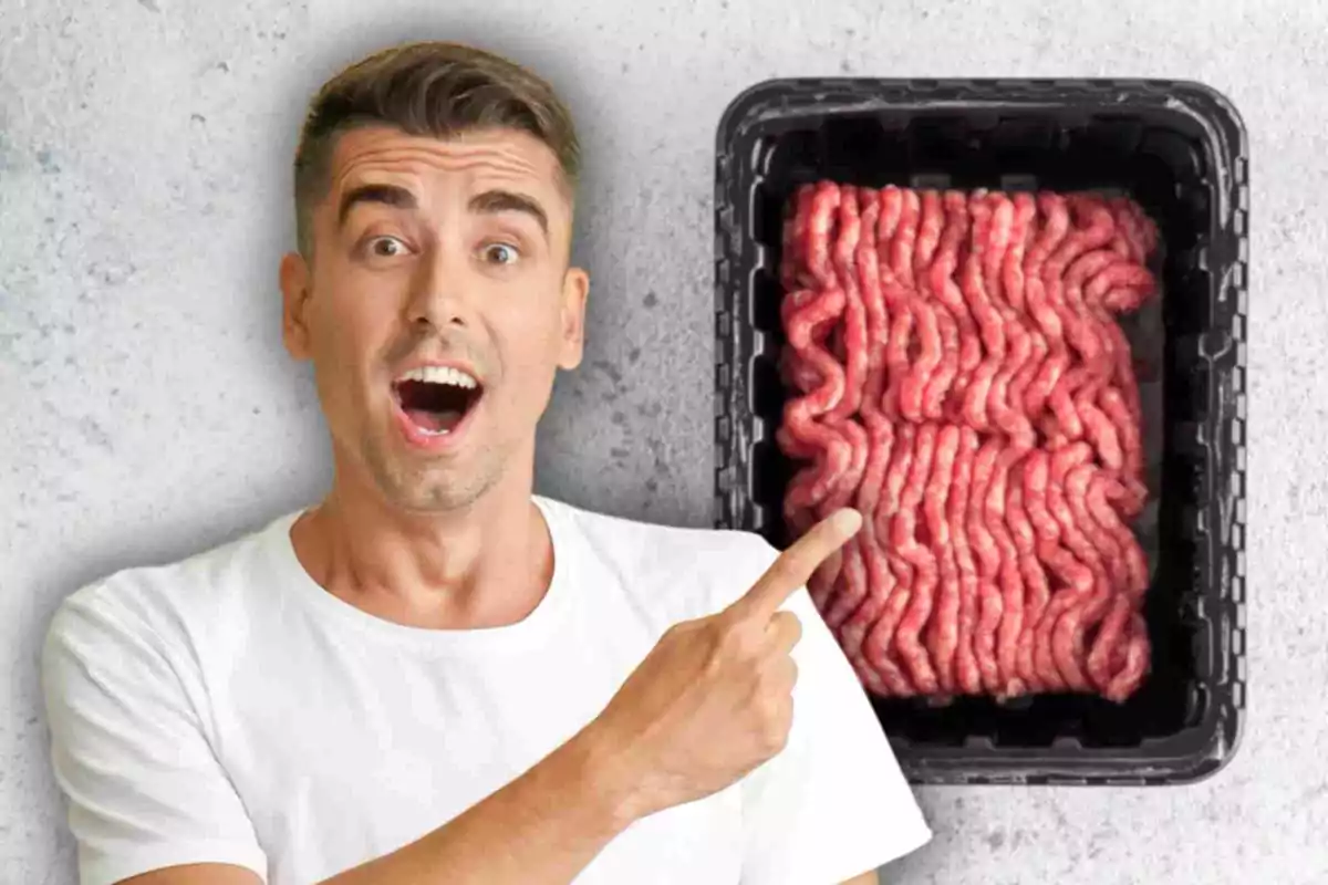 Un hombre sorprendido señala un paquete de carne molida en una bandeja negra.