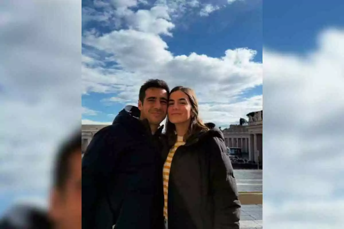 Alberto Herrera and his girlfriend Blanca posing outdoors with a blue sky and clouds in the background.