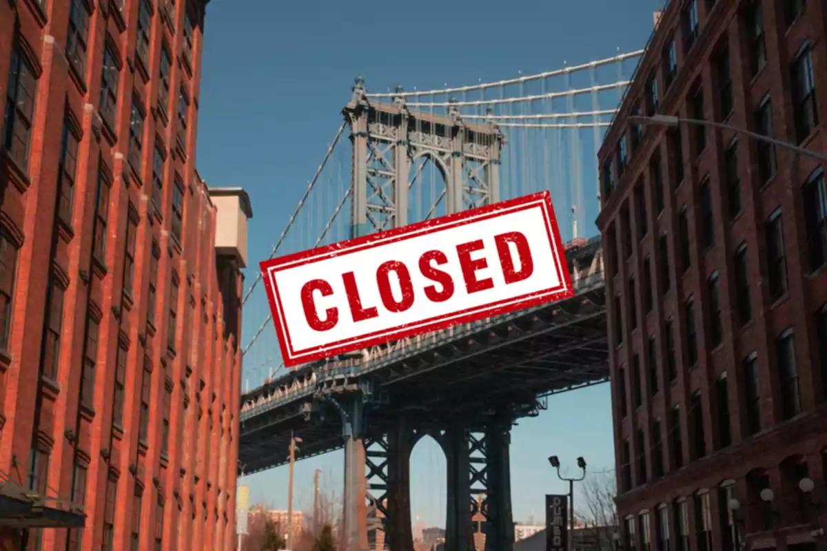 View of a bridge between brick buildings with a sign that says View of a bridge between brick buildings with a sign that says