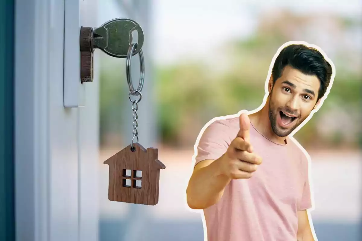 Un hombre sonriente señalando hacia adelante con una llave en una cerradura y un llavero en forma de casa.