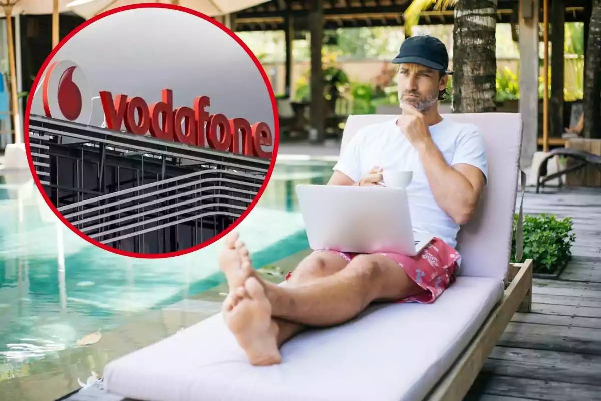 Un hombre sentado en una tumbona junto a una piscina, trabajando en una computadora portátil y sosteniendo una taza. En la esquina superior izquierda de la imagen hay un círculo que muestra el logotipo de Vodafone en un edificio.
