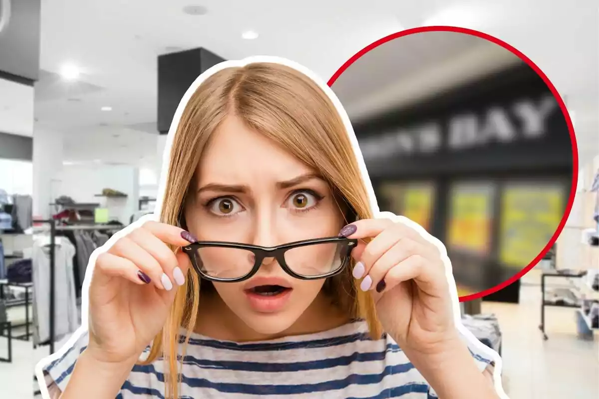 Young woman with a surprised expression adjusting her glasses in a clothing store
